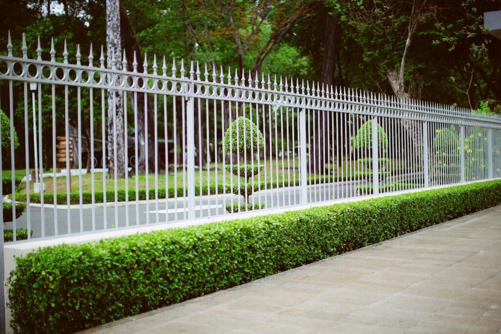 A sturdy fence bordering lush green grass built by local fence contractors.