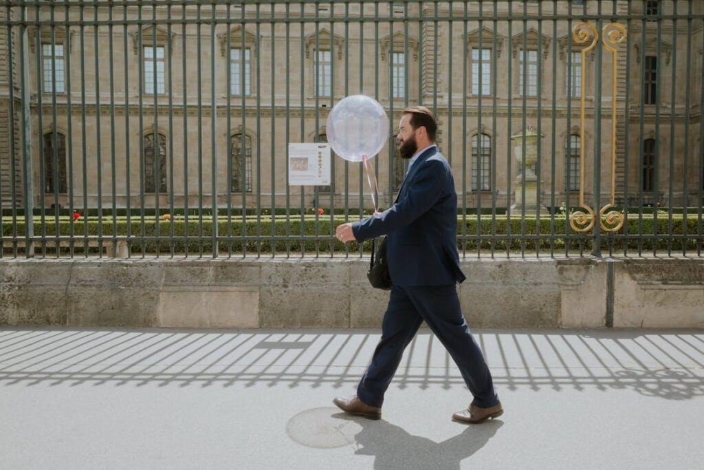 Businessman walking past a tall commercial security fence in Camden County